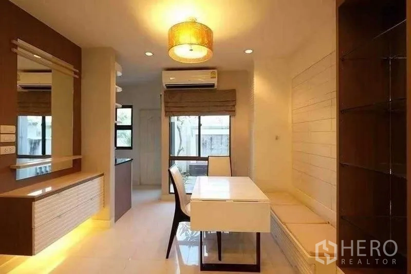 联排别墅 出租在Phra Khanong, Bangkok - 紧凑餐区，内置长凳、吊灯与窗景。