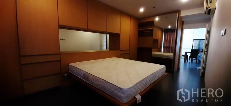 Condominium for rent in Phaya Thai, Bangkok - Primary bedroom with platform bed, abundant built-in storage and soft lighting.