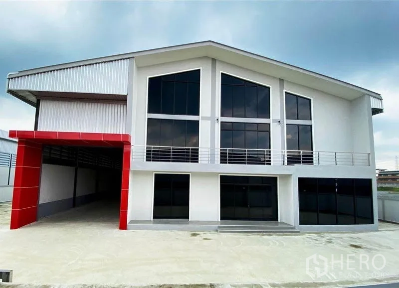 Warehouse for sale in Krathum Baen, Samut Sakhon - Modern two-storey warehouse facade with large glazing and a red covered loading bay.