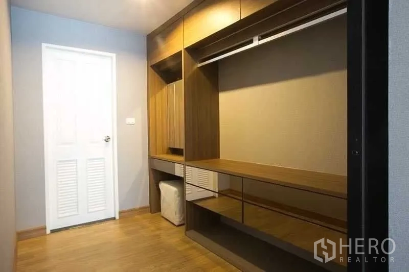 Condominium for rent in Khlong Toei, Bangkok - Walk-in closet with full-height wooden wardrobes and dressing counter.