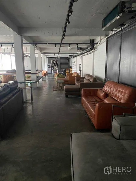 零售空间 出租在Bang Na, Bangkok - 极简展厅内宽阔通道、沙发与楼梯