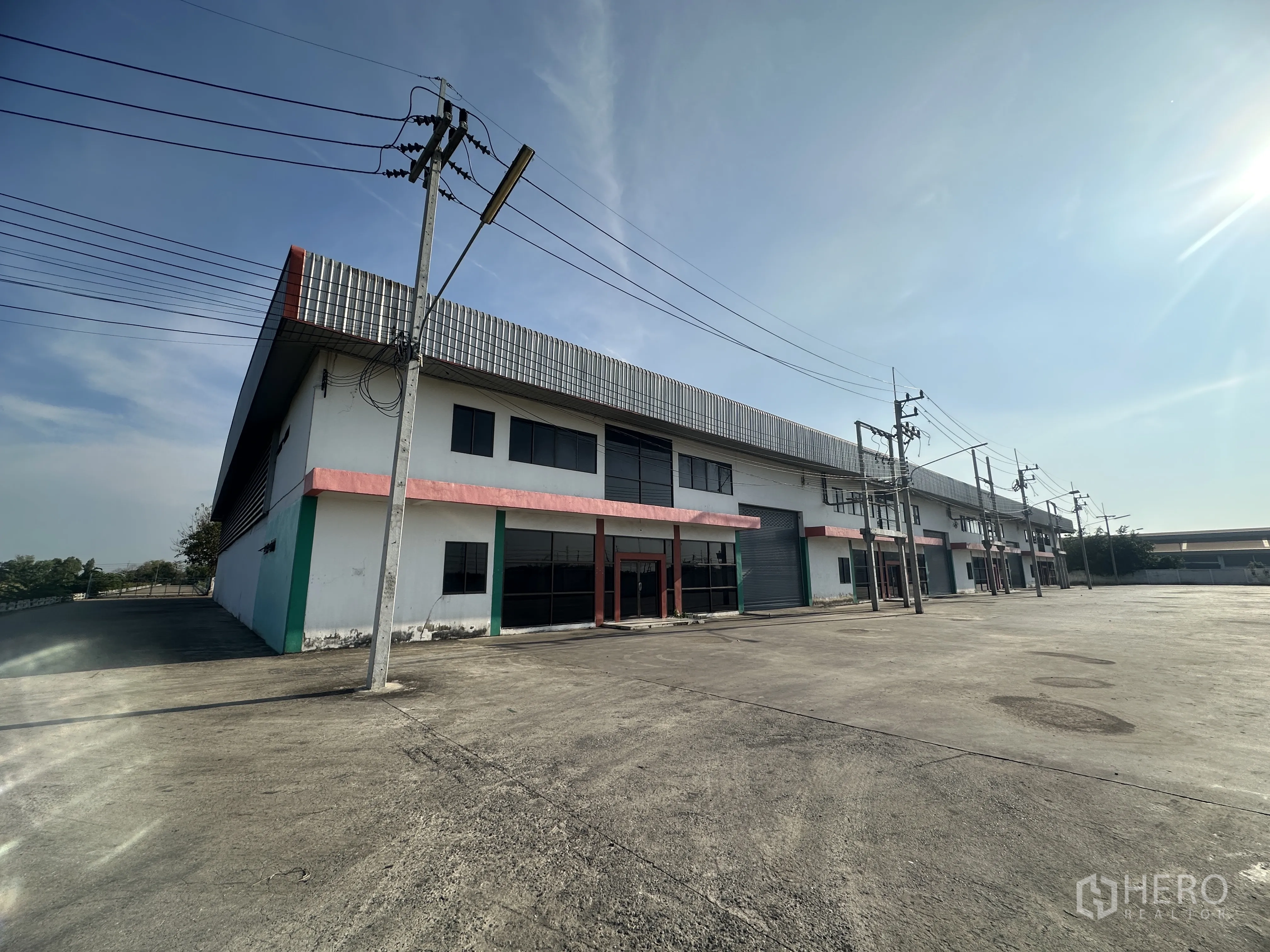 工厂 for rent in Wang Noi, Phra Nakhon Si Ayutthaya - 工厂排楼前角度，玻璃办公立面、卷闸门与宽阔混凝土场地。