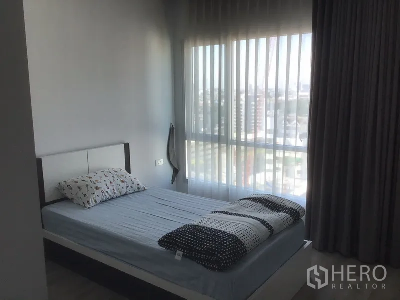 Condominium for rent in Sathon, Bangkok - Second bedroom with floor-to-ceiling windows, sheer curtains and open city view.