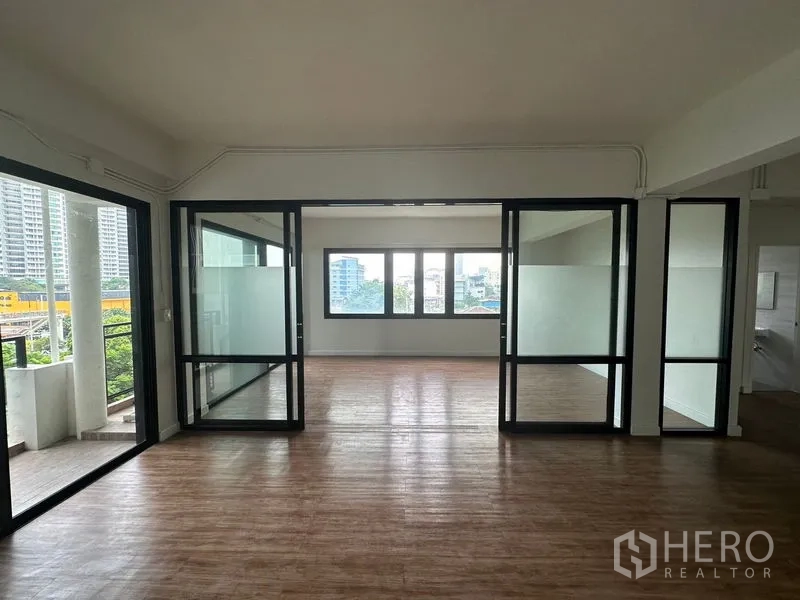 Office Space for rent in Sathon, Bangkok - Central room with full-height glass walls between two open areas and windows framing city views.