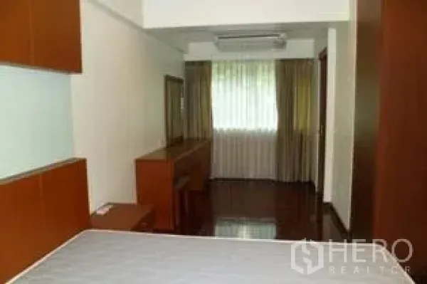 公寓 出租在Pathum Wan, Bangkok - 明亮卧室，木地板，内置柜与书桌，大窗配窗帘采光充足