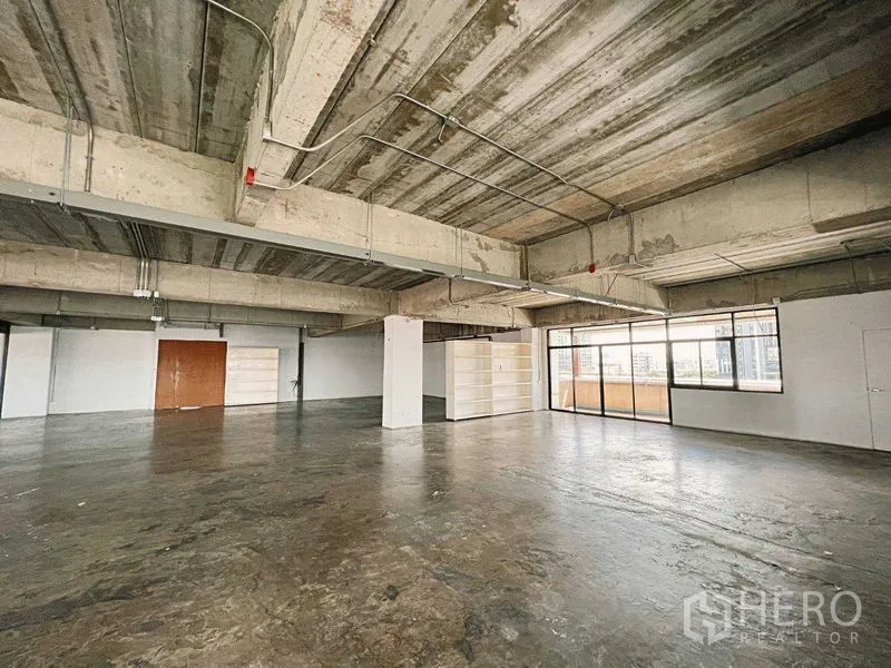 Retail Space for rent in Yan Nawa, Bangkok - Open-plan level with shelving, double doors, and balcony access.