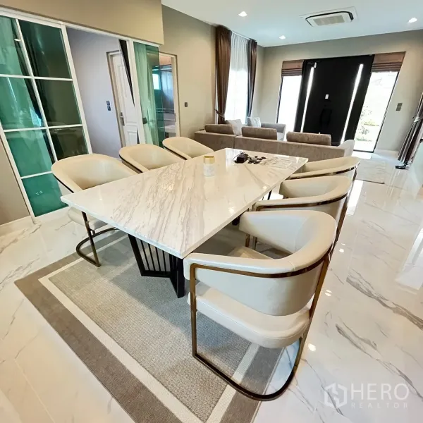 Detached House for rent or sale in Bang Khen, Bangkok - Open‑plan dining and living space with sliding glass doors and glossy floors.