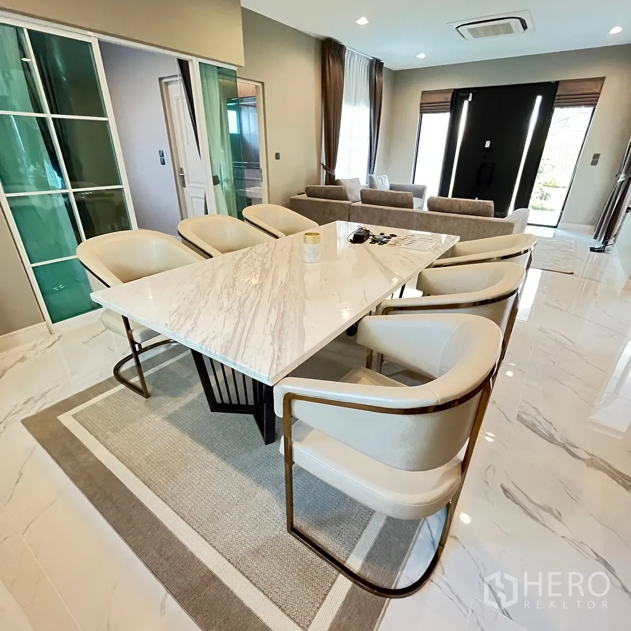Detached House for rent or sale in Bang Khen, Bangkok - Open‑plan dining and living space with sliding glass doors and glossy floors.