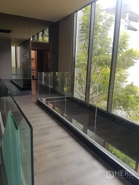 Retail Space for rent in Khlong Toei, Bangkok - Upper corridor with floor-to-ceiling windows and glass balustrade overlooking greenery.
