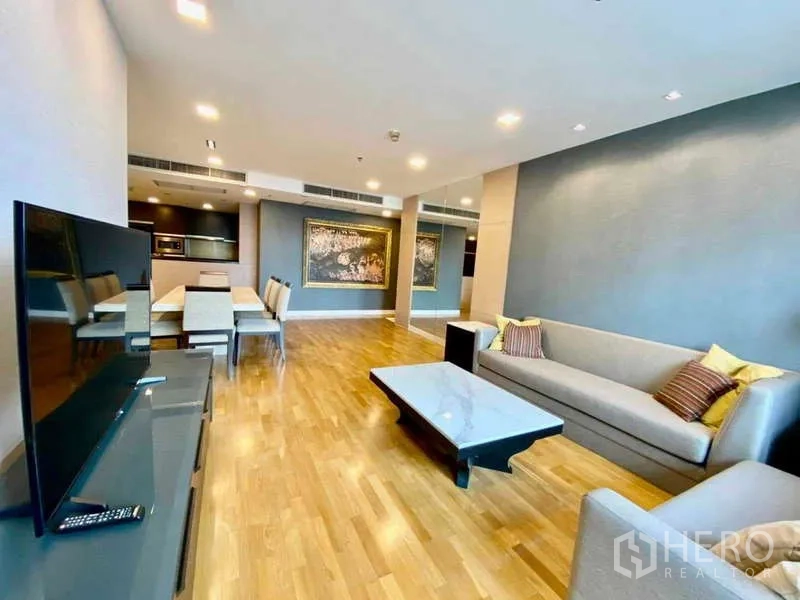 Condominium for rent or sale in Sathon, Bangkok - Spacious living room with two sofas, TV console, and large wall mirror.