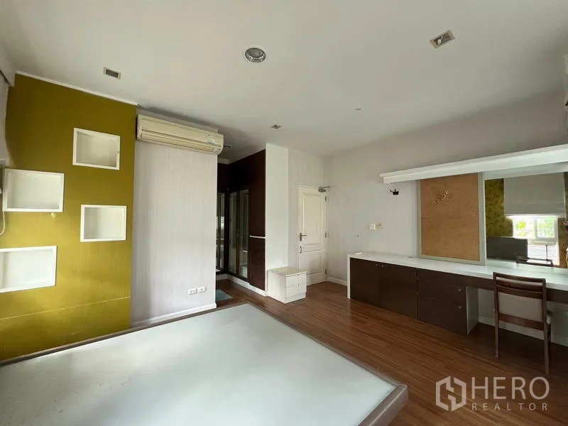 Detached House for rent in Bang Kapi, Bangkok - Master bedroom corner with long dressing table, built-in wardrobes and wood floor.