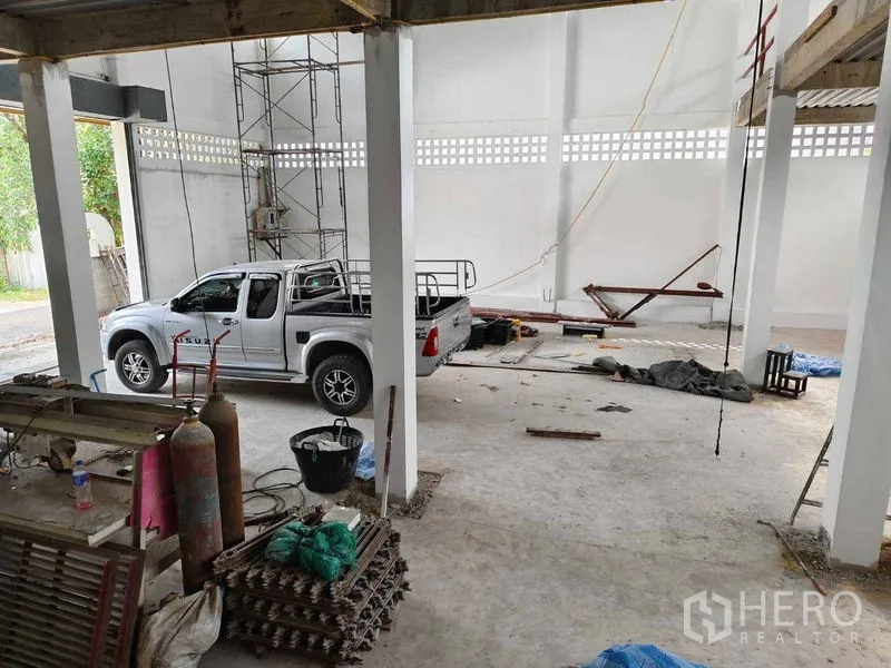 Warehouse for rent in Phra Khanong, Bangkok - Open warehouse floor with wide entrance, scaffolding, and drive-in area for small trucks.