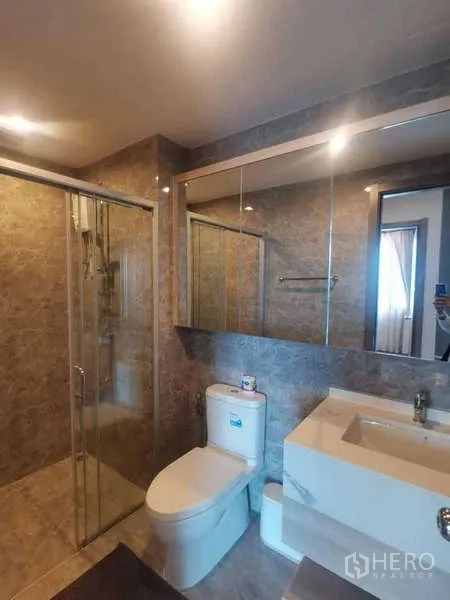 คอนโด ขายในHuai Khwang, Bangkok - ห้องน้ำสมัยใหม่ พร้อมตู้ฝักบัวกระจก ตู้กระจกบานใหญ่ และผนังกระเบื้องลายหิน