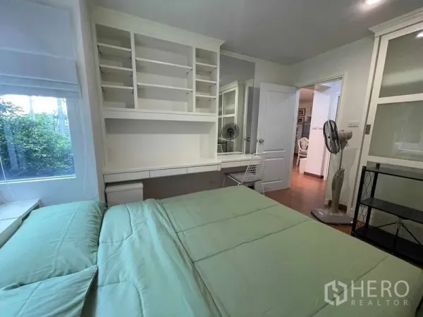 Condominium for rent - Bedroom angle showing work desk, shelving and window overlooking greenery.