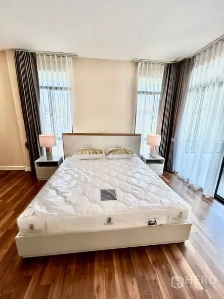 独栋房屋 for rent or sale in Prawet, Bangkok - 主卧配特大床与床头柜，落地转角窗并可通往阳台。