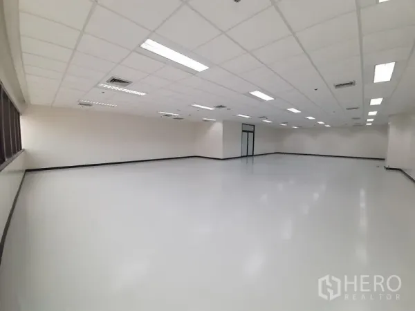 Office Space for rent in Bang Rak, Bangkok - Spacious office floor with suspended ceiling lights and a continuous band of windows on one side.