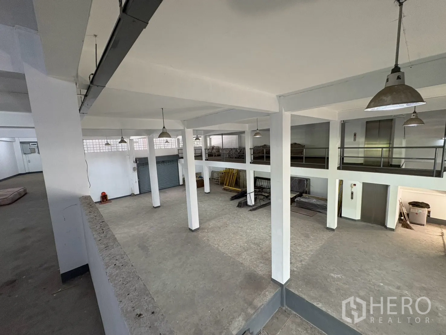 Warehouse for rent in Bang Na, Bangkok - View from the mezzanine over the open warehouse floor with pendant lights.