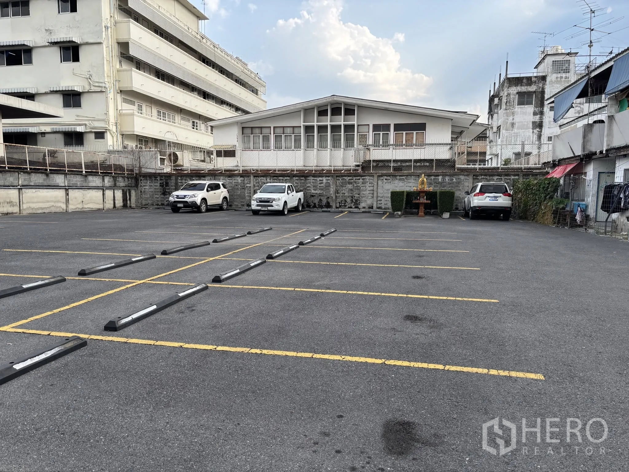 ที่ดิน for rent in Sathon, Bangkok - ลานจอดรถลาดยางพร้อมเส้นแบ่งช่องและตัวกันล้อ รายล้อมด้วยอาคารเตี้ย