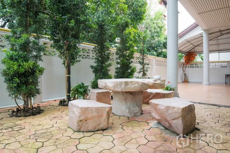 Detached House for rent or sale in Bang Kapi, Bangkok - Courtyard garden with stone table and stools under a canopy.