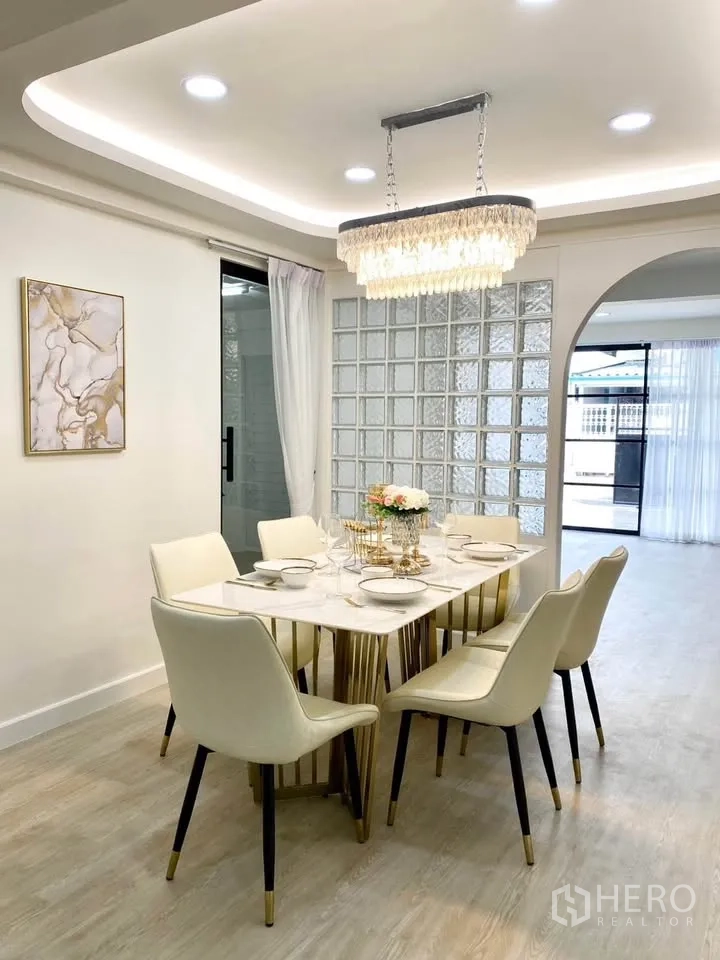 บ้านเดี่ยว for rent in Huai Khwang, Bangkok - ห้องรับประทานอาหาร โต๊ะลายหินสำหรับหกที่นั่ง โคมแชนเดอเลียร์ และผนังกระจกบล็อก