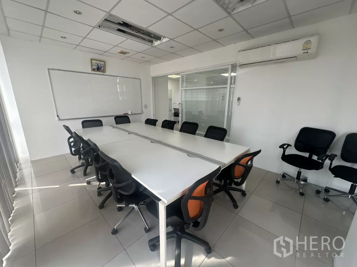 สำนักงาน ให้เช่าในHuai Khwang, Bangkok - ห้องประชุมพร้อมโต๊ะยาว เก้าอี้หลายตัว กระดานไวท์บอร์ด และเครื่องปรับอากาศติดผนัง