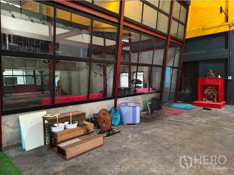 货栈 出租在Khlong Toei, Bangkok - 倾斜玻璃隔断，旁有混凝土地面与杂物区。