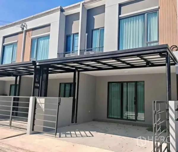 Townhouse for rent in Bang Phli, Samut Prakan - Modern townhouse exterior with covered carport, sliding glass doors and gated entrance.