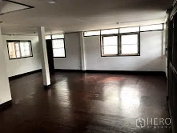 บ้าน ให้เช่าในSuan Luang, Bangkok - ห้องนั่งเล่นกว้างพื้นไม้สีเข้มและหน้าต่างหลายบาน