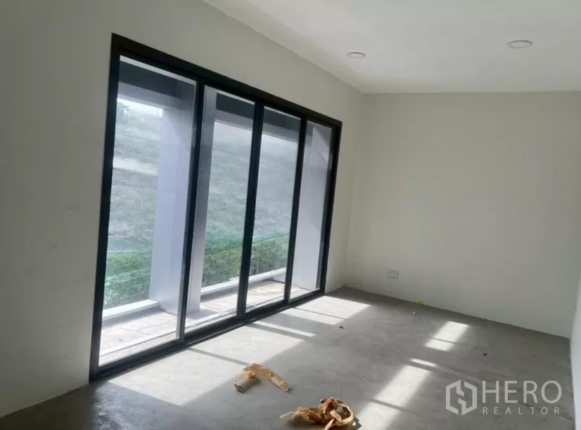 店屋 出租在Watthana, Bangkok - 采光充足的楼层，落地推拉玻璃门通向阳台。