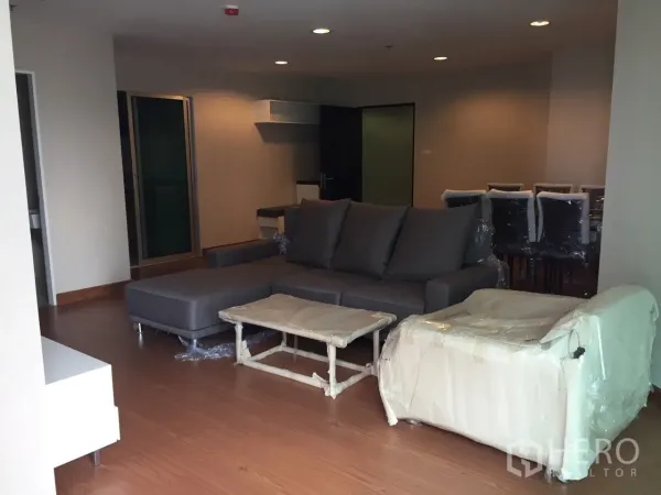 คอนโด ให้เช่าในHuai Khwang, Bangkok - ห้องนั่งเล่นกว้าง โซฟารูปตัวแอล พื้นไม้ และไฟฝังฝ้า ในคอนโดห้วยขวาง.
