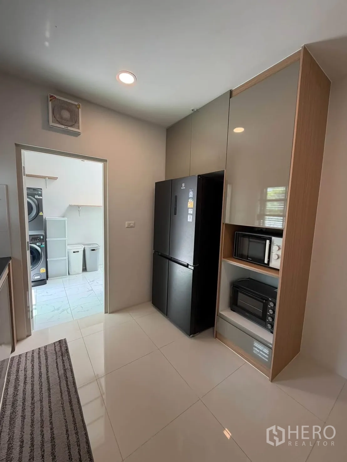 独栋房屋 for rent in Bang Phli, Samut Prakan - 厨房带黑色冰箱与内置微波炉、烤箱，外接洗衣区。