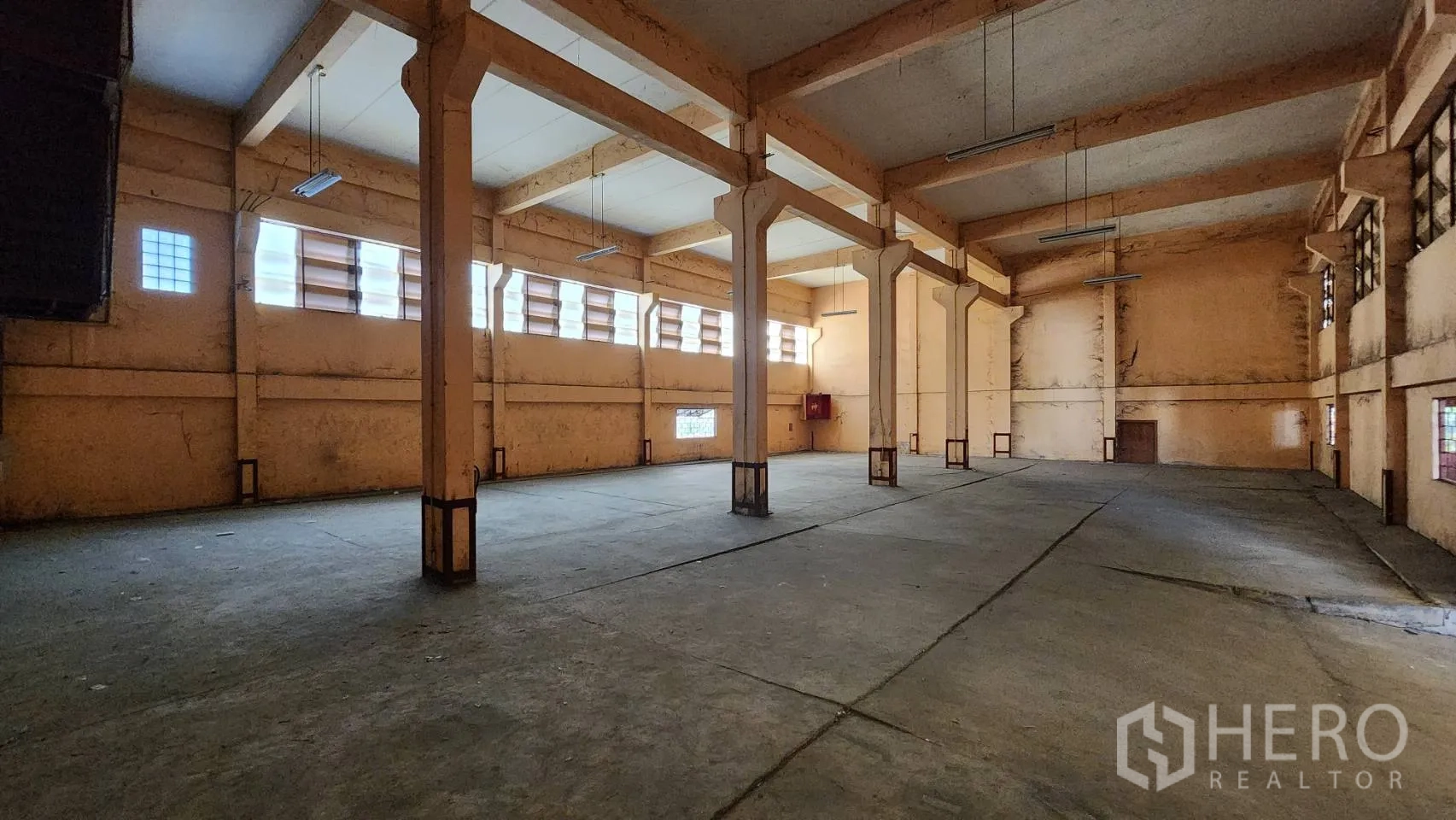 Warehouse for rent in Nonthaburi - Second connected unit with rows of concrete columns and high ceiling.