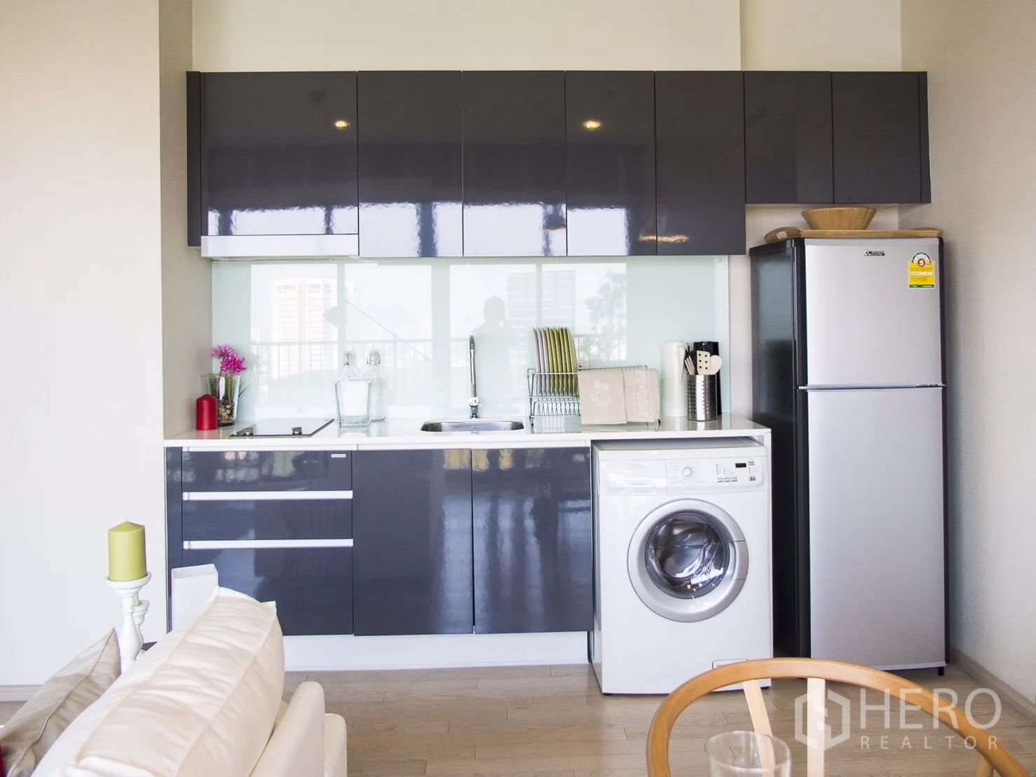 Condominium for rent in Watthana, Bangkok - Compact kitchen with glossy cabinets, sink, fridge and front-load washing machine.