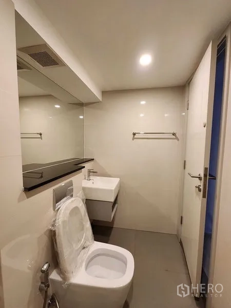 公寓 出售在Sathon, Bangkok - 极简浴室，壁挂洗手盆、坐便器与筒灯。