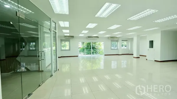 办公空间 出租 - 开放工作区，玻璃隔断入口，亮面地砖、LED灯，窗外绿意。