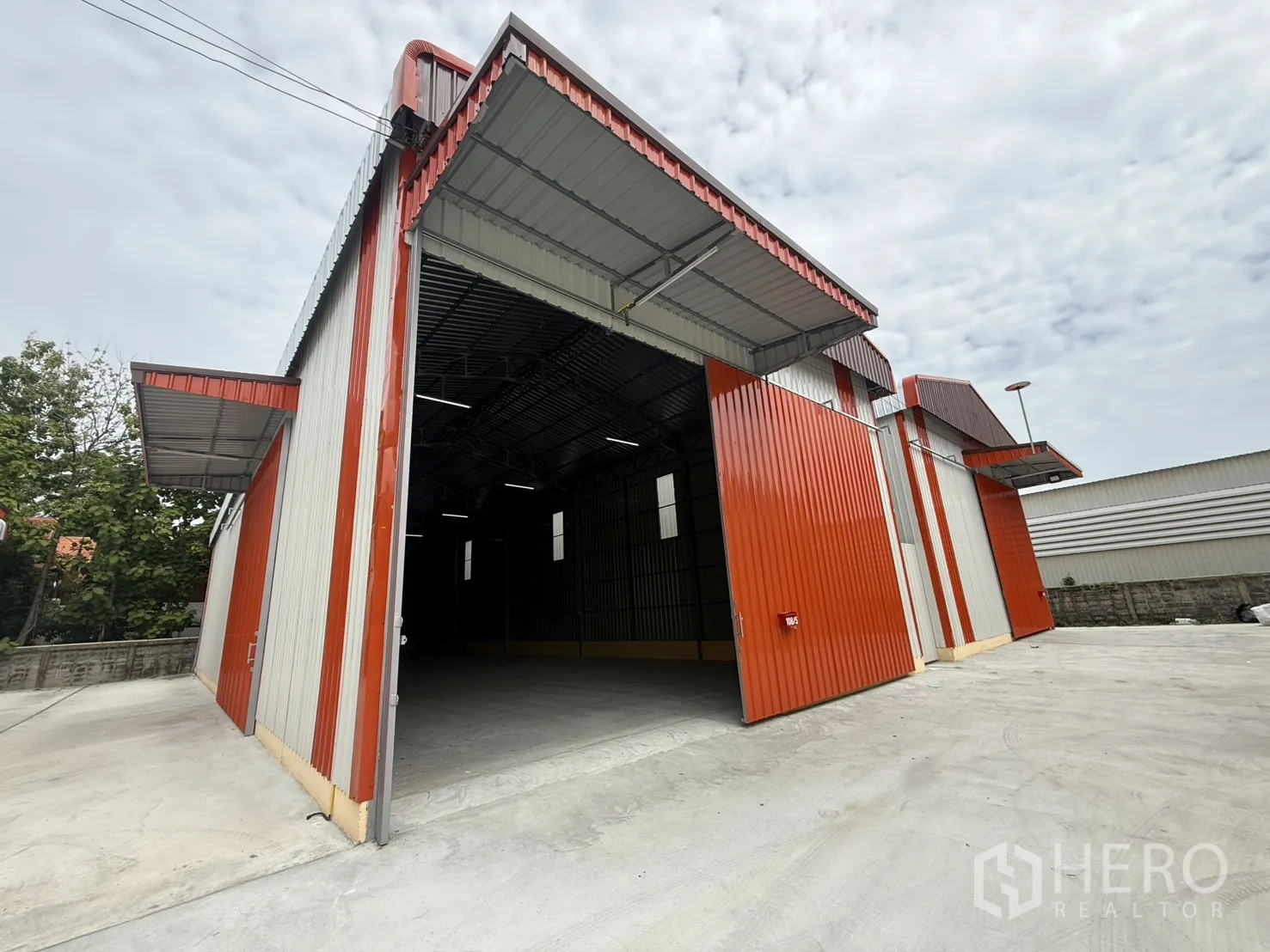 仓库 for rent in Wang Thonglang, Bangkok - 仓库外观，敞开的大型推拉门与混凝土装卸平台。