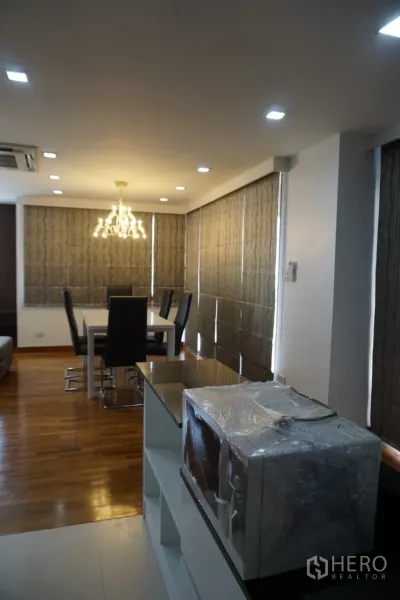 公寓 出租在Watthana, Bangkok - 靠窗餐区，卷帘与吊灯，木地板采光良好