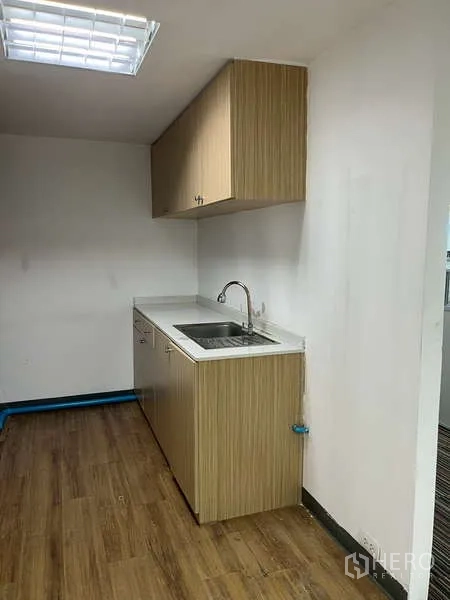 Office Space for rent - Compact pantry with wood cabinets, countertop, sink, and wood flooring.