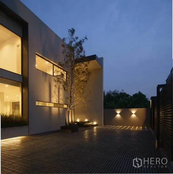 带办公室的家 出售在Wang Thonglang, Bangkok - 曼谷旺通朗现代风格住宅式办公楼外观，黄昏时庭院灯光与景观树。