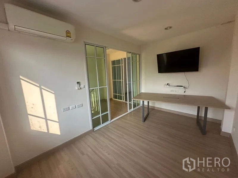 Home Office for rent in Bang Na, Bangkok - Small meeting room with desk, wall-mounted TV and air conditioner.