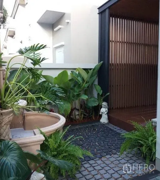 独立式住宅 出售在Nonthaburi - 小型景观花园，水景与盆栽，鹅卵石步道与木质屏风。