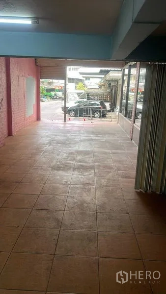 零售空间 出租在Bang Na, Bangkok - 从店内向门口望去的开阔空间，可见门外路边停车区。