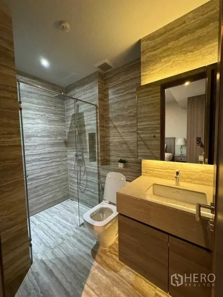 คอนโด ให้เช่าในWatthana, Bangkok - ห้องน้ำสไตล์โมเดิร์น ปูกระเบื้องลายหิน ฝักบัวกระจก ใต้อ่างล้างหน้าไฟส่องสว่าง และโถสุขภัณฑ์.