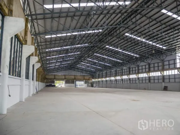 工厂 出租在Pathum Thani - 超大仓库大厅，钢桁架屋顶与天窗，开阔装卸通道。