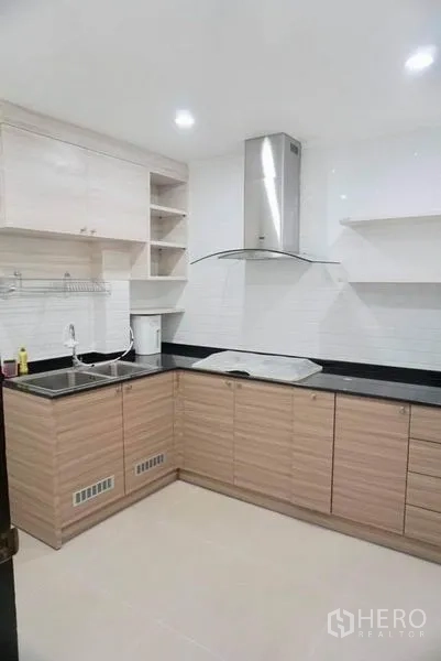 独立式住宅 出租在Suan Luang, Bangkok - 现代L形厨房，木纹橱柜、黑色台面、水槽与抽油烟机。