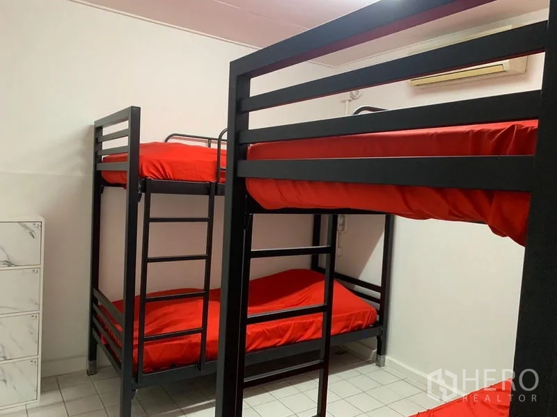 Shophouse for rent in Khlong Toei, Bangkok - Air-conditioned dorm room with metal bunk beds, red bedding, and lockers on a white tiled floor.