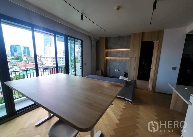 公寓 出租或出售在Phaya Thai, Bangkok - 客餐厅铺人字拼木地板，连接阳台，尽览城市天际线景观。