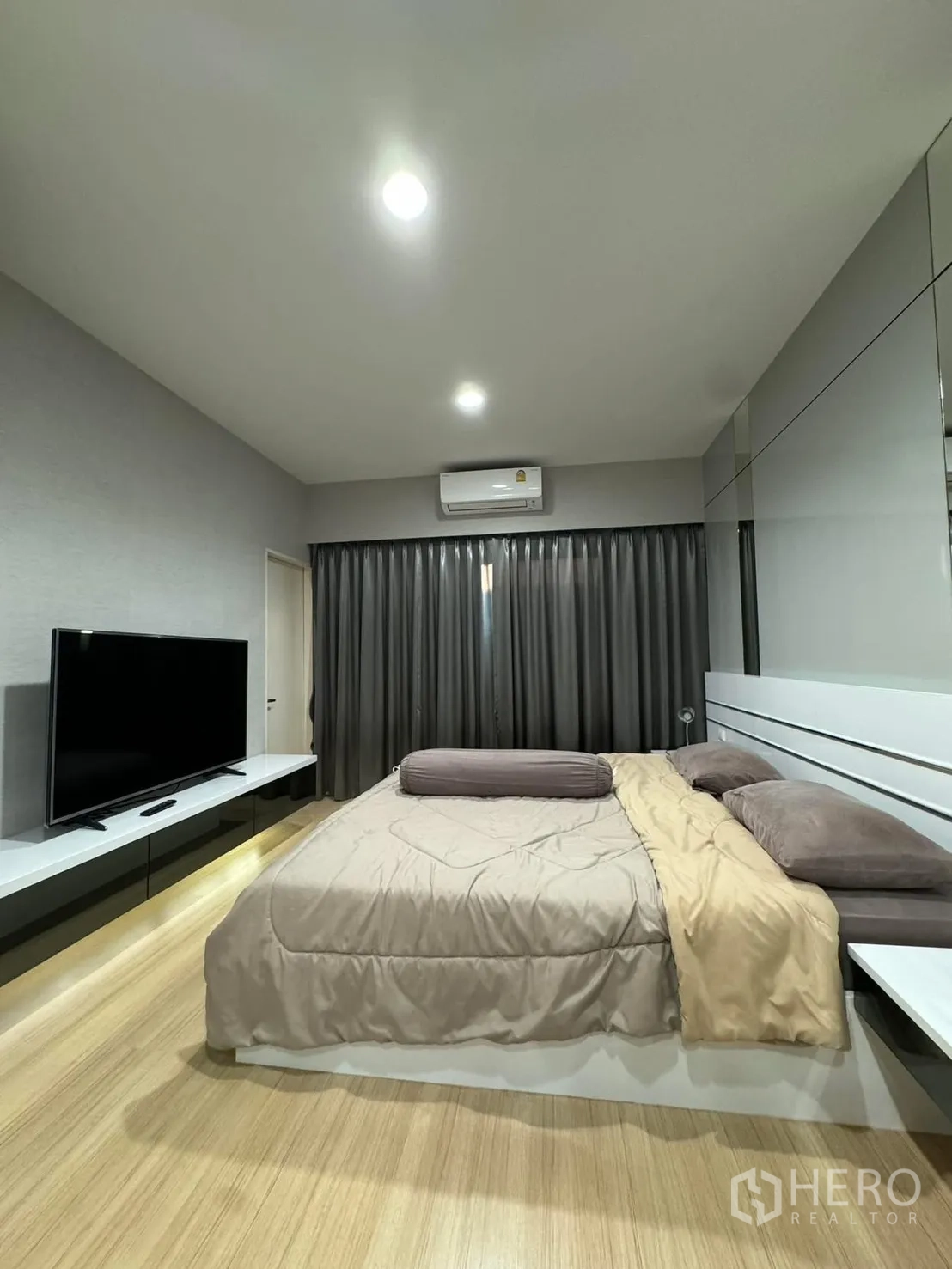 Townhouse for rent in Suan Luang, Bangkok - Master bedroom with king bed, TV console, air conditioner and floor-to-ceiling curtains.