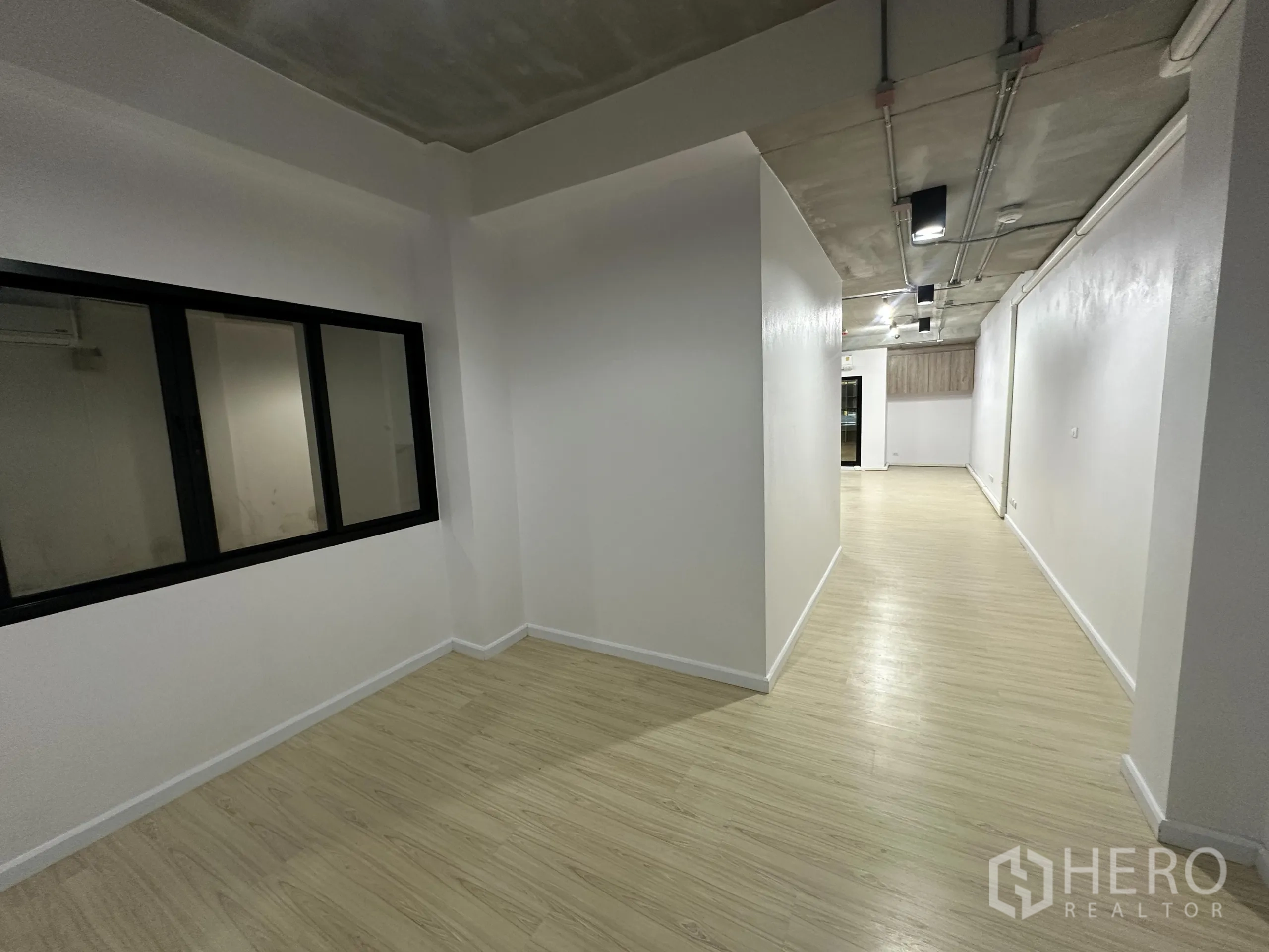 办公空间 出租在Watthana, Bangkok - 带内部窗的走道，通向开放式主办公区。