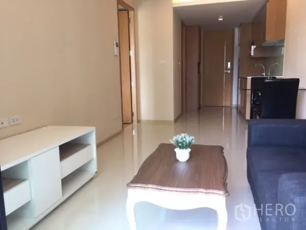 公寓 出租或出售在Pathum Wan, Bangkok - 采光充足的客厅与开放式小厨房，亮面地砖与阳台推拉门。